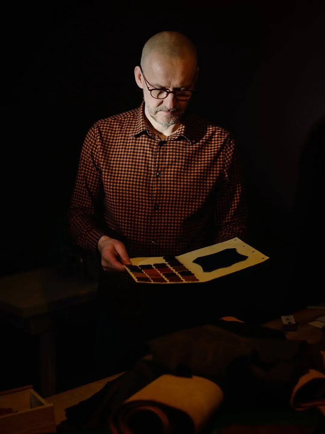 Robert Szwajka dobiera próbki materiałów do naprawy obuwia